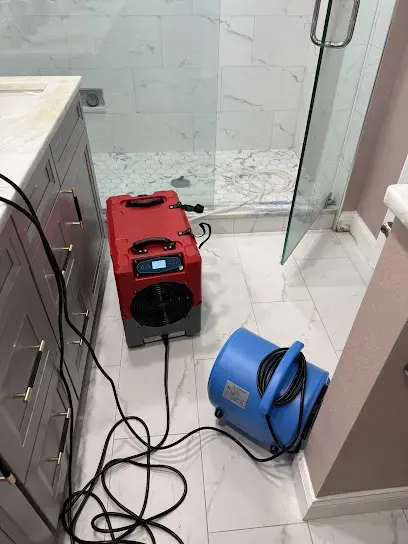 Dehumidifier and air mover drying a tiled bathroom in Lutz, FL