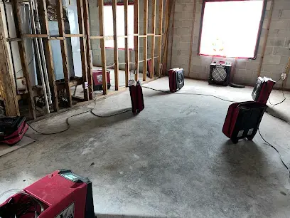 Dehumidifiers drying a gutted room with concrete block walls in Hillsborough County