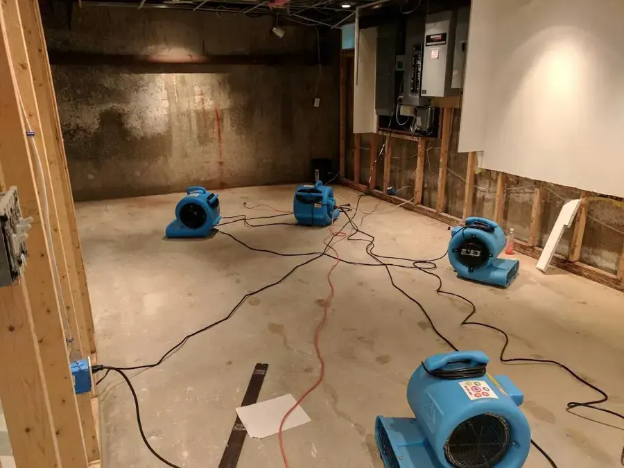 Air movers drying a gutted room with the drywall cut out in a Lutz, FL home