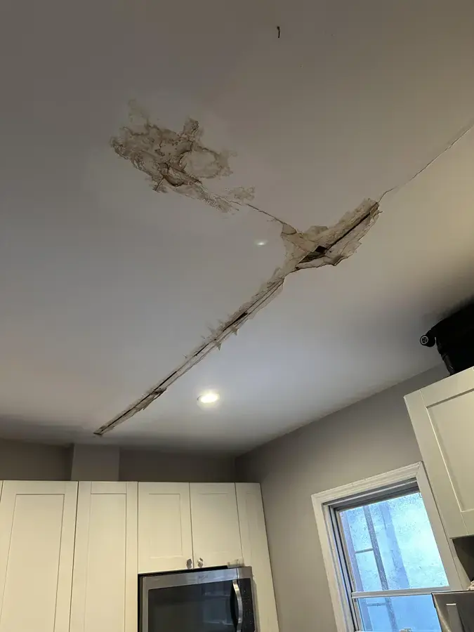 Cracked, water-stained ceiling drywall from a leak above in a Lutz home