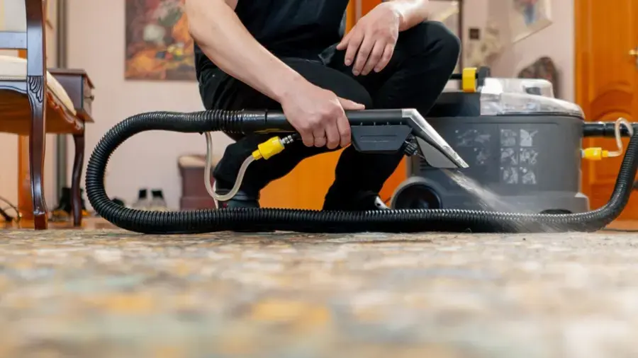 Technician running an extraction wand over wet carpet during a Lutz, FL water damage cleanup