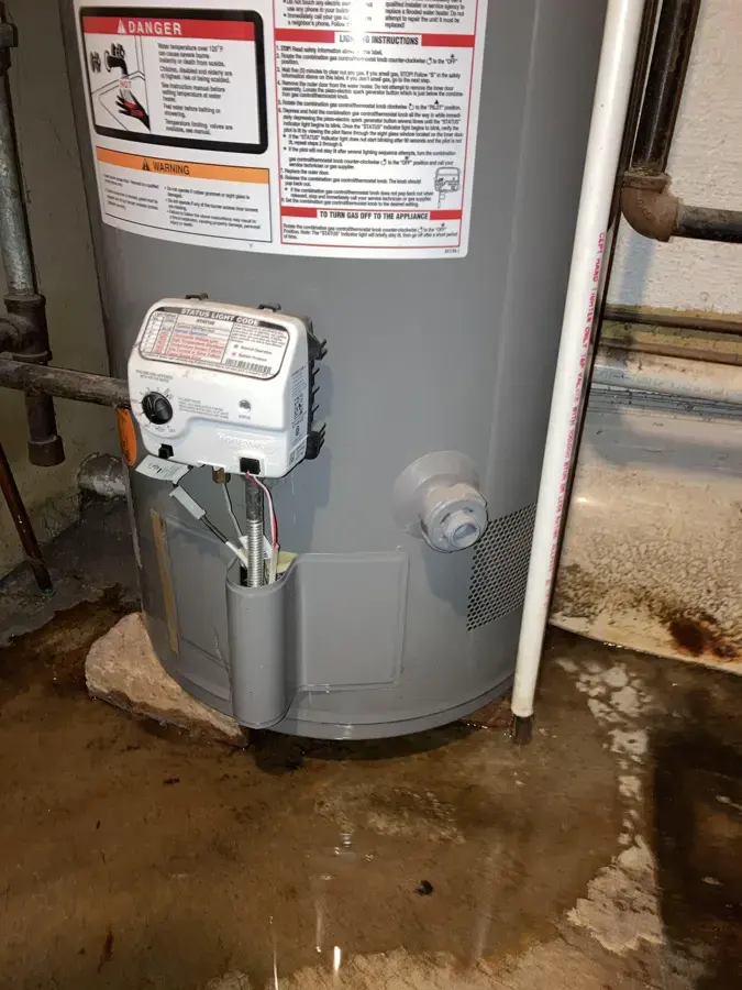Water pooled around the base of a tank water heater